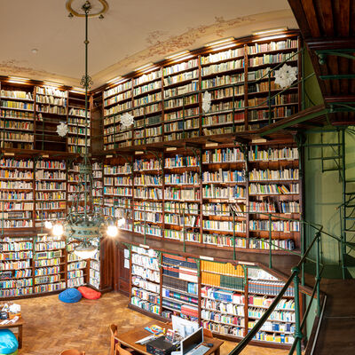 Bild vergrößern: Alte, hohe, hölzerne Bibliothek mit vielen Büchern.